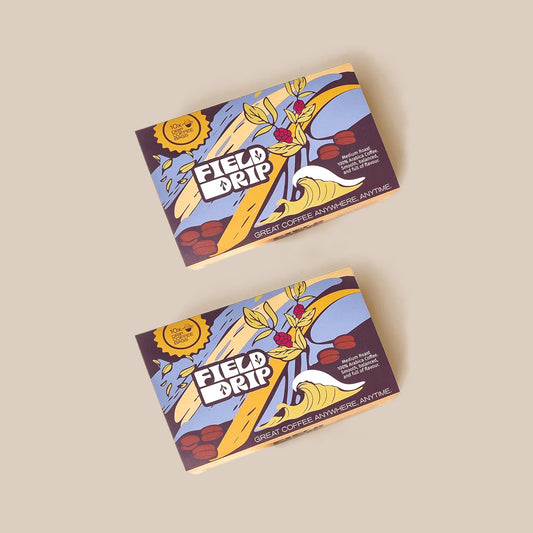 Two Field Drip drip coffee boxes (10 bags each) with wave and coffee branch illustration, on a beige background.